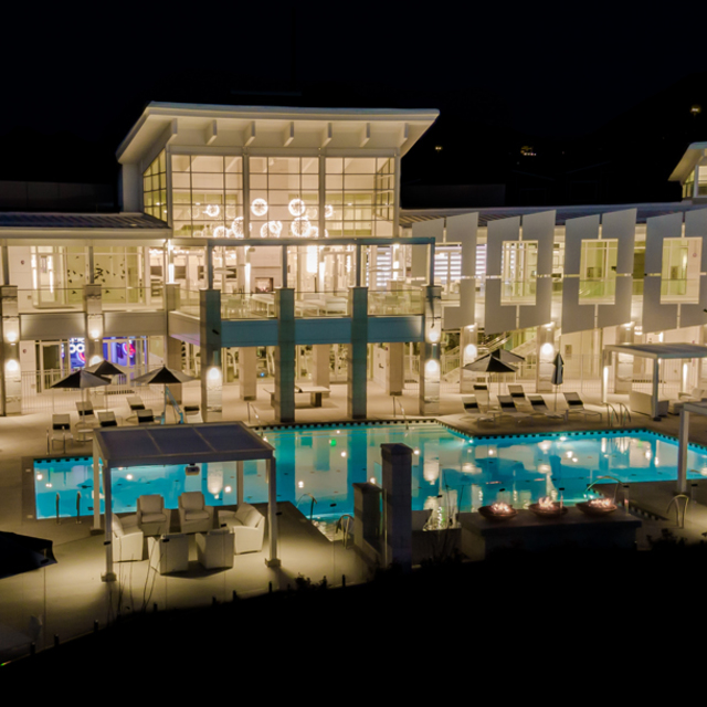 Rockpoint Apartments - Night Shot of Clubhouse Facade with Resort-Style Lap Pool 